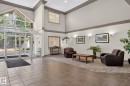 Spacious entryway featuring a vaulted ceiling and an expansive glass enclosure - 122 279 Suder Greens Drive, Edmonton, AB 