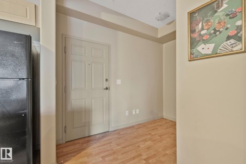 Entryway with wood-finish flooring, a paneled door, and neutral wall paint - 209 5280 Terwillegar Boulevard, Edmonton, AB - Indoor Photo Showing Other Room