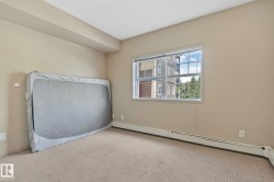 Carpeted room featuring a large window, neutral wall paint, white trim, and baseboard heating - 