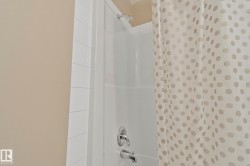 White subway tile surround within a shower-over-tub combination featuring chrome fixtures - 