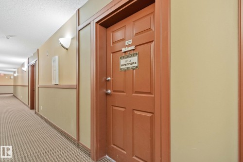 Entry door with paneled design and prominent silver hardware - 209 5280 Terwillegar Boulevard, Edmonton, AB - Indoor Photo Showing Other Room