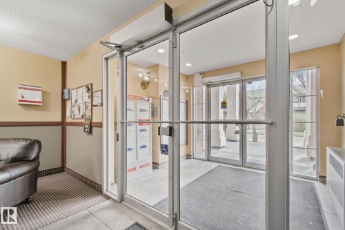 Glass entry doors with aluminum frames, recessed overhead lighting, and a neutral color palette - 209 5280 Terwillegar Boulevard, Edmonton, AB - Indoor Photo Showing Other Room