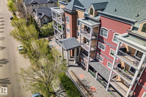 Multi-story building featuring red and tan siding, multiple private balconies, and a covered entrance - 209 5280 Terwillegar Boulevard, Edmonton, AB - Outdoor