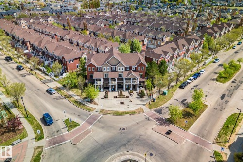 Aerial perspective of a residential neighborhood featuring rows of multi-story townhomes with varying exterior finishes and pitched roofs - 209 5280 Terwillegar Boulevard, Edmonton, AB - Outdoor With View