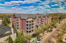 Multi-story building featuring a red and tan facade, multiple balconies with dark railings, and a dark shingled roof - 209 5280 Terwillegar Boulevard, Edmonton, AB  - Outdoor With View 