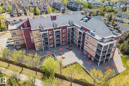 Multi-story residential building with private balconies and a central paved courtyard - 209 5280 Terwillegar Boulevard, Edmonton, AB - Outdoor