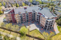 Multi-story residential building with private balconies and a central paved courtyard - 