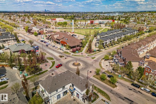 Aerial perspective showcasing a mixed-use development with commercial buildings, townhomes, and single-family residences - 209 5280 Terwillegar Boulevard, Edmonton, AB - Outdoor With View