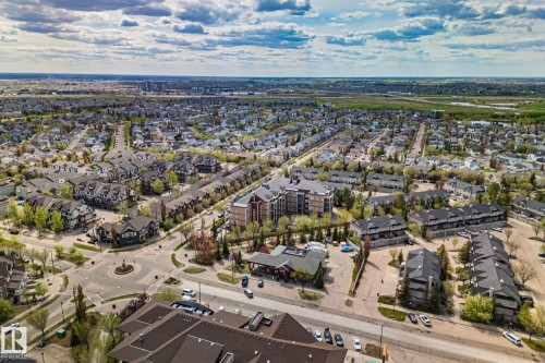 Aerial perspective showcasing a residential community with diverse housing types, including multi-story apartment buildings and townhome complexes - 209 5280 Terwillegar Boulevard, Edmonton, AB - Outdoor With View