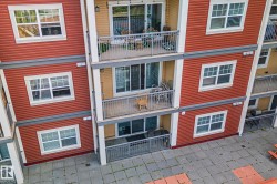Multi-story building exterior with red horizontal siding and white trim - 