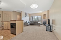 Open-concept living area with a built-in fireplace, sliding glass doors, and a breakfast bar with an integrated dishwasher - 