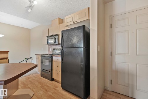 Kitchen featuring wood-finish flooring and light wood cabinetry - 209 5280 Terwillegar Boulevard, Edmonton, AB - Indoor Photo Showing Kitchen