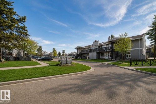 Multi-story building featuring gray siding, dark trim, and individual balconies - 23 1503 Mill Woods Road E, Edmonton, AB 