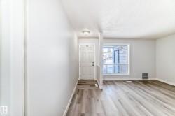 Entryway featuring a paneled door, flush mount ceiling light, and wood-finish flooring - 