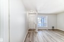 Entryway featuring a paneled door, flush mount ceiling light, and wood-finish flooring - 23 1503 Mill Woods Road E, Edmonton, AB 