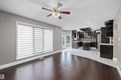 Expansive interior with dark wood-finish flooring and light gray walls - 