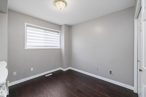Neutral wall finishes with dark wood-finish flooring - 4831 154 Avenue, Edmonton, AB 