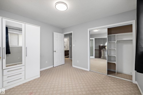 Bedroom featuring patterned carpet, light grey walls, and a flush mount ceiling light - 4831 154 Avenue, Edmonton, AB 