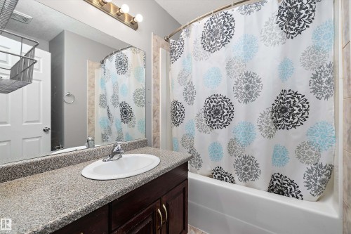 Bathroom featuring a spacious vanity with a speckled countertop and a built-in sink - 4831 154 Avenue, Edmonton, AB 