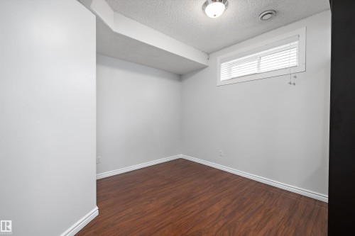 Room featuring wood-finish flooring, white baseboards, and light gray painted walls - 4831 154 Avenue, Edmonton, AB 