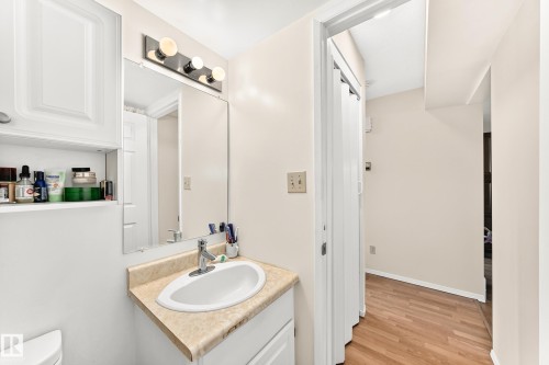 Bathroom vanity featuring a single basin sink, chrome faucet, and a light-toned countertop - 102 Royal Terrace, Edmonton, AB 