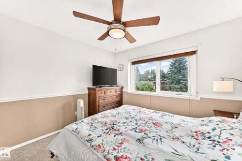 Spacious room featuring a ceiling fan with integrated lighting, a broad window with wood blinds, and two-tone wall finishes - 102 Royal Terrace, Edmonton, AB 