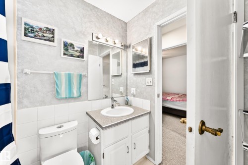 Bathroom featuring a single vanity with a laminate countertop, white ceramic sink, and chrome faucet - 102 Royal Terrace, Edmonton, AB 