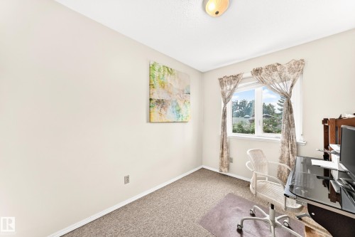 Bright interior room with light-colored walls, textured carpeting, and a window providing natural illumination - 102 Royal Terrace, Edmonton, AB 