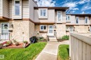 Townhouse exterior featuring a concrete pathway, a stucco and siding facade, and a raised flower bed - 102 Royal Terrace, Edmonton, AB 