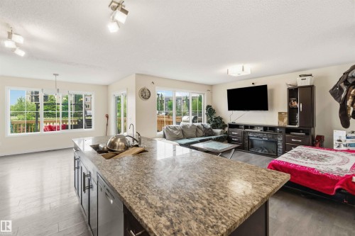 Kitchen island featuring a granite-style countertop and integrated sink - 5120 19 Avenue, Edmonton, AB 