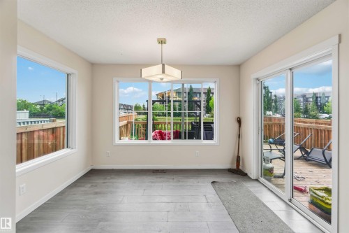 Spacious room featuring wood-finish flooring, light-colored walls, and a contemporary ceiling fixture - 5120 19 Avenue, Edmonton, AB 