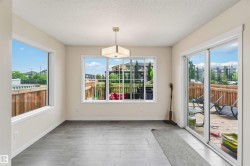Spacious room featuring wood-finish flooring, light-colored walls, and a contemporary ceiling fixture - 