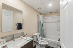 Bathroom featuring a white vanity with an integrated sink, polished chrome faucet, and a large wall-mounted mirror - 