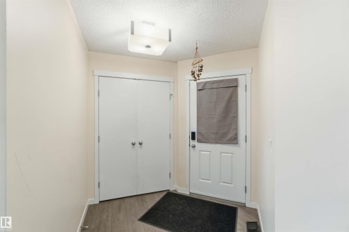 Entryway featuring light-toned walls, wood-finish flooring, and a flush-mount ceiling fixture - 5120 19 Avenue, Edmonton, AB 