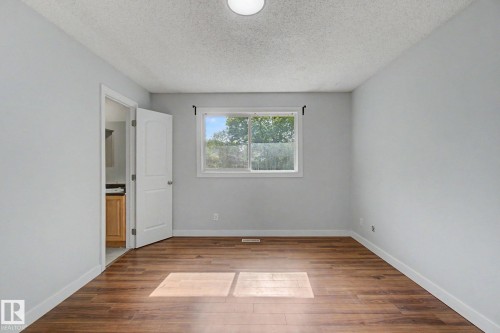 Bright interior space featuring wood-finish flooring, light grey walls, and a white trim package - 1511 75 Street, Edmonton, AB 