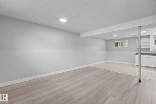 Finished lower level featuring recessed lighting, light wood-finish flooring, and white baseboards - 1511 75 Street, Edmonton, AB 