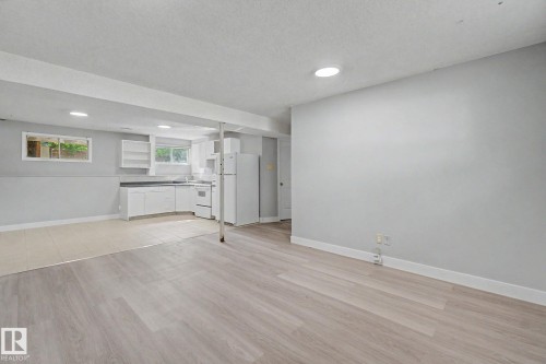 Open-concept living space featuring light wood-finish flooring, recessed lighting, and a neutral wall color - 1511 75 Street, Edmonton, AB 
