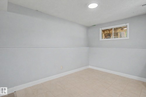 Room featuring light gray walls with a chair rail, recessed ceiling lighting, and a single window - 1511 75 Street, Edmonton, AB 