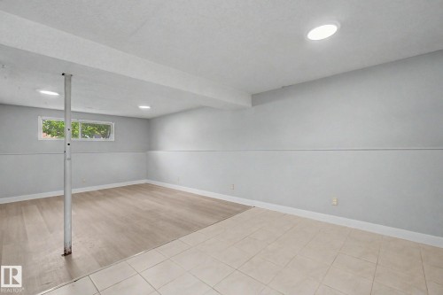 Spacious lower level room featuring recessed lighting, a window, wood-finish flooring, and light-toned tile flooring - 1511 75 Street, Edmonton, AB 