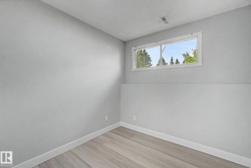Interior room featuring light gray walls, white trim, and wood-finish flooring - 1511 75 Street, Edmonton, AB 