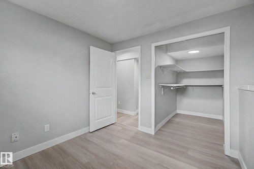 Bedroom featuring light gray walls, white trim, and wood-finish flooring - 1511 75 Street, Edmonton, AB 