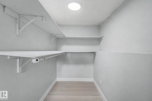 Dedicated storage space featuring built-in shelving, wood-finish flooring, recessed lighting, and crisp white trim - 1511 75 Street, Edmonton, AB 