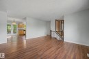 Spacious living area featuring wood-finish flooring, light gray wall paint, and white trim - 1511 75 Street, Edmonton, AB 