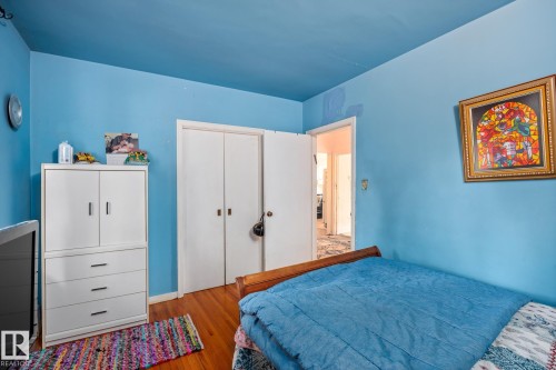 Hardwood flooring throughout featuring white bi-fold closet doors and an open doorway - 11022 110 Avenue, Edmonton, AB 