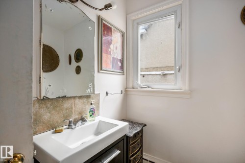 White vanity sink with a chrome faucet, set against a tiled backsplash - 11022 110 Avenue, Edmonton, AB 