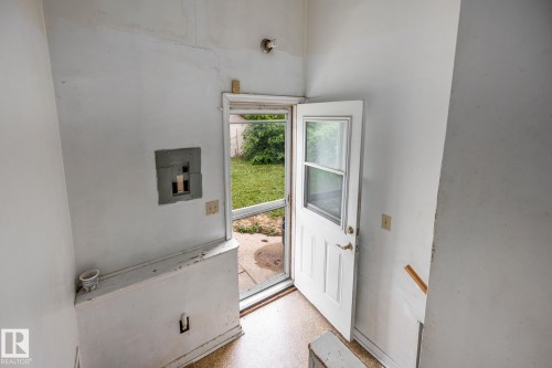White paneled door with glass insert, leading to a green outdoor space - 11022 110 Avenue, Edmonton, AB 
