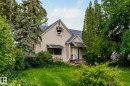 Stucco exterior with a peaked roofline, featuring decorative window awnings and a covered front entry with steps - 11022 110 Avenue, Edmonton, AB 