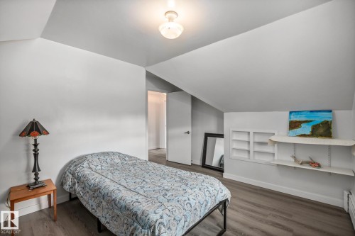 Attic room featuring sloped ceilings, light wood-finish flooring, and white painted walls - 11022 110 Avenue, Edmonton, AB 
