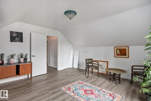 Room featuring sloped ceilings, light-tone wood-finish flooring, and white walls - 11022 110 Avenue, Edmonton, AB 