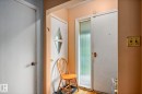 Entryway featuring a white door with a diamond-shaped window, a second white door with an opaque glass panel, and light wood-finish flooring - 11022 110 Avenue, Edmonton, AB 